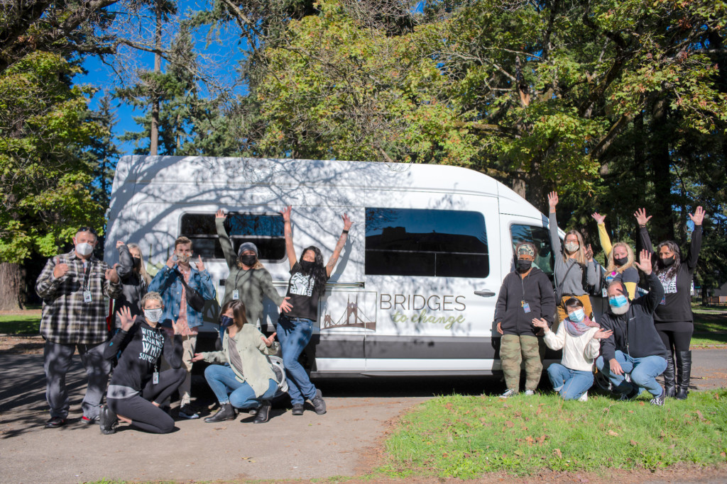 Staff of Bridges to Change, a drug addiction treatment service in Oregon, with one of the organization's vehicles.